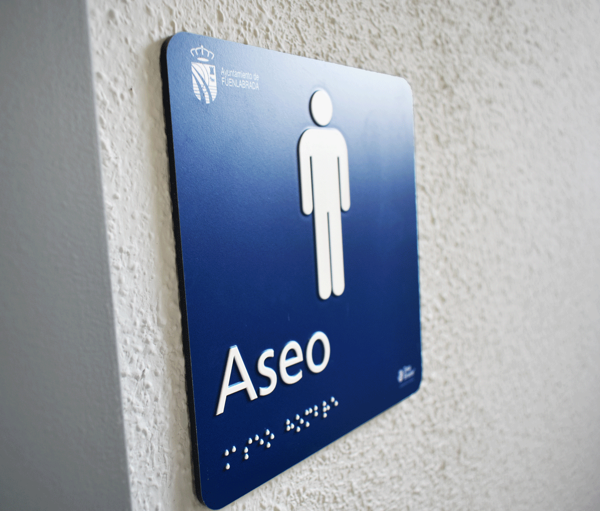 Señal aseo hombre con braille y altorelieve