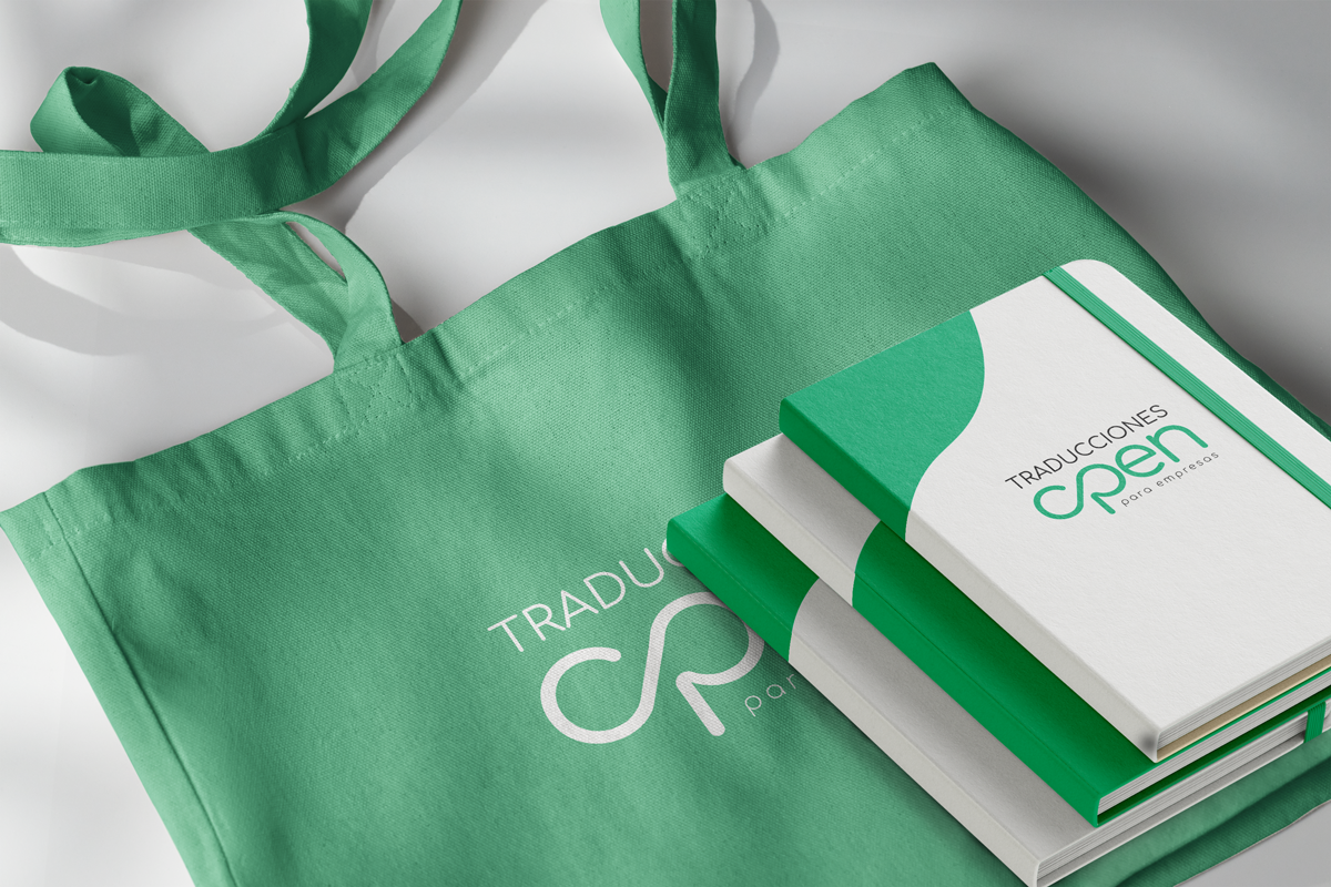 Libretas y bolsa corporativa con el logo de Traducciones Open